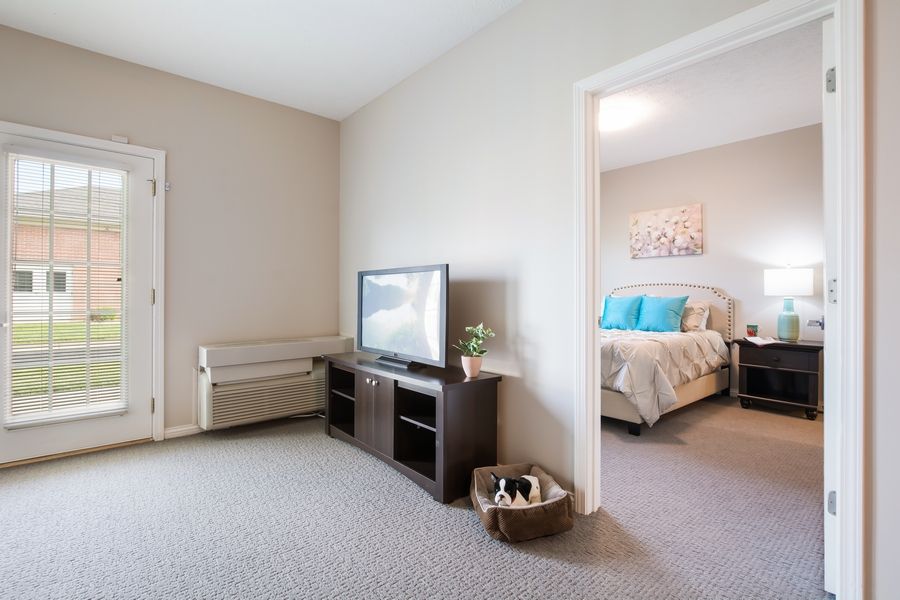 A cozy living space with a view into a neatly designed bedroom.
