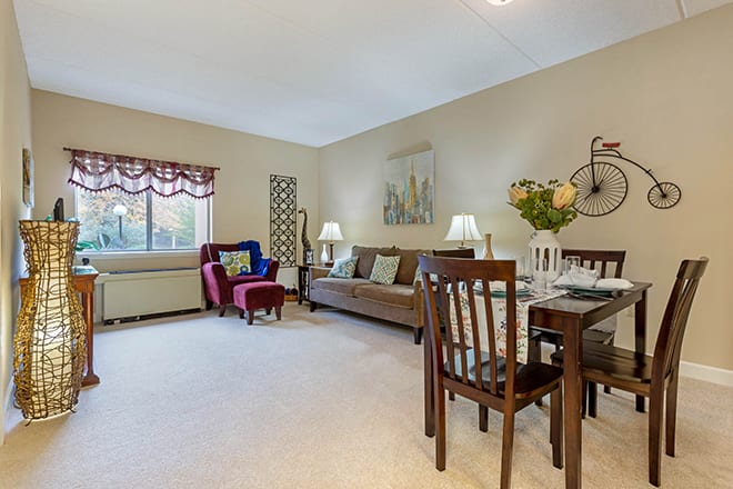 A cozy living room with a dining area, featuring comfortable furniture and elegant decor.