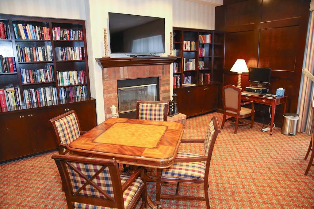 Cozy living room with a bookshelf, fireplace, and a seating area.