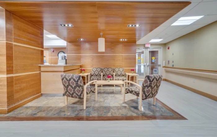 A modern lobby with a comfortable seating area and wood-paneled walls.