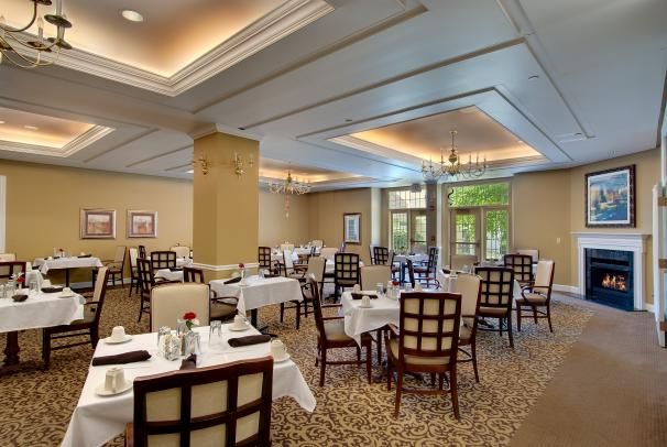 An elegant restaurant dining room with neatly arranged tables and chairs.