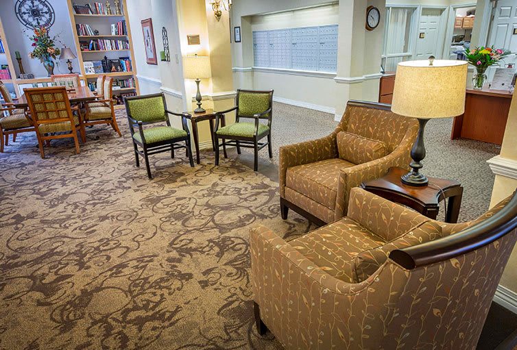 A cozy seating area in a lobby with chairs and lamps, featuring elegant carpet and interior design.