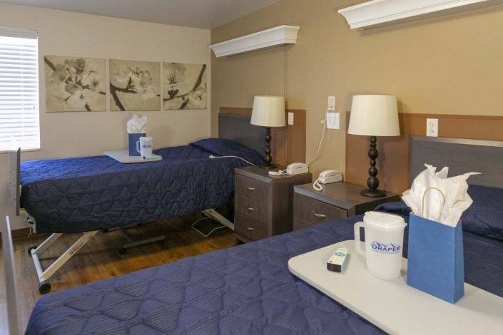 Hospital room with two beds and medical equipment.