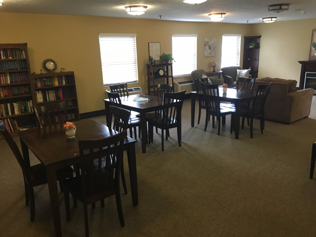 A quiet dining area with multiple wooden tables and chairs arranged neatly.