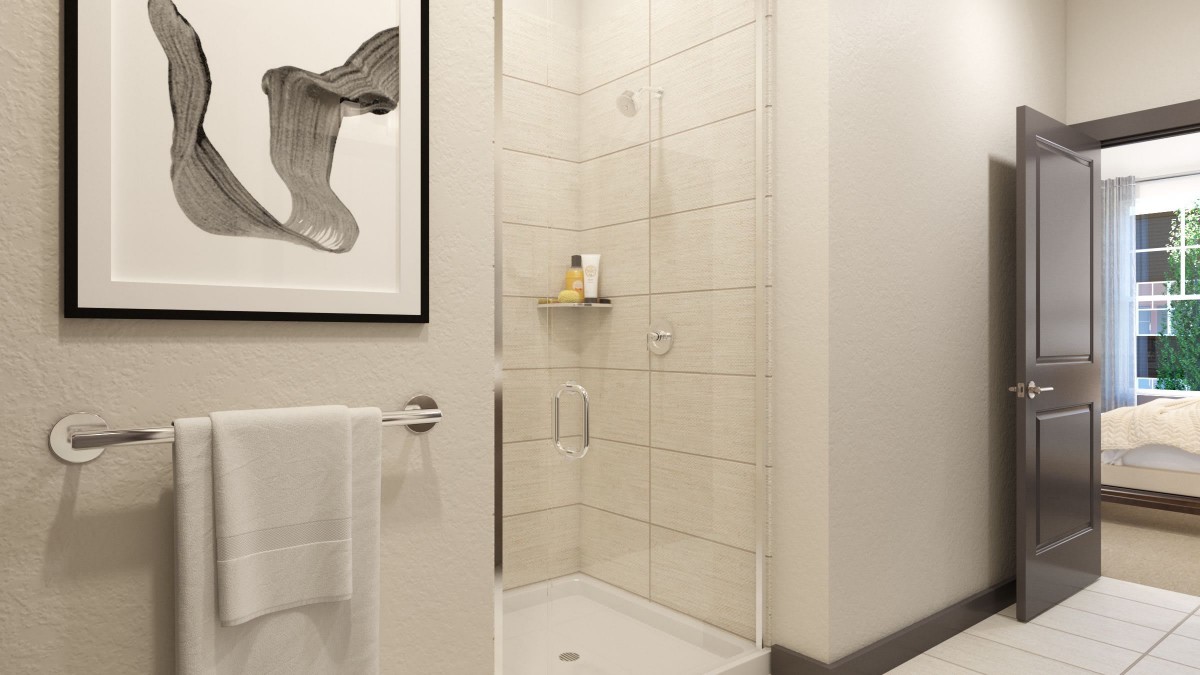 A modern and minimalist bathroom with a glass shower enclosure and tiled walls.
