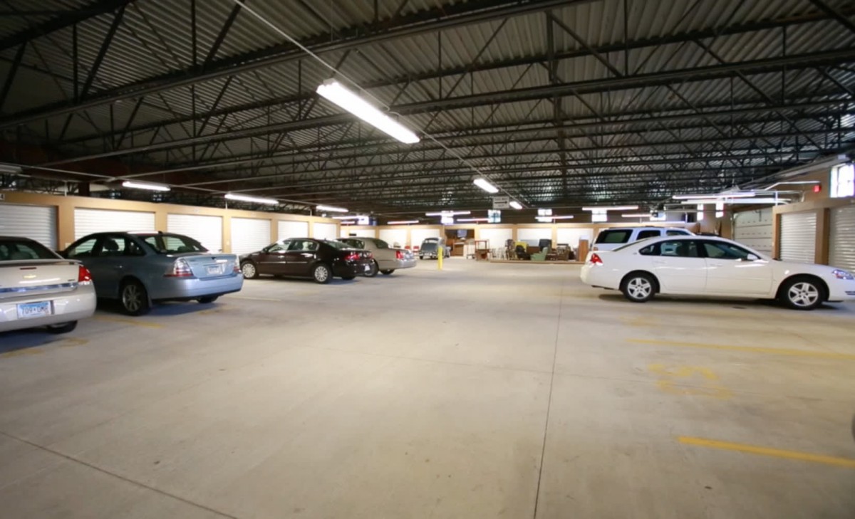 An indoor parking garage with several parked cars and overhead lighting.