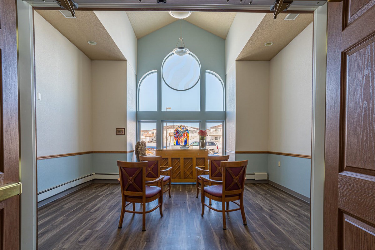 A cozy seating area with four chairs around a window in a well-lit room.
