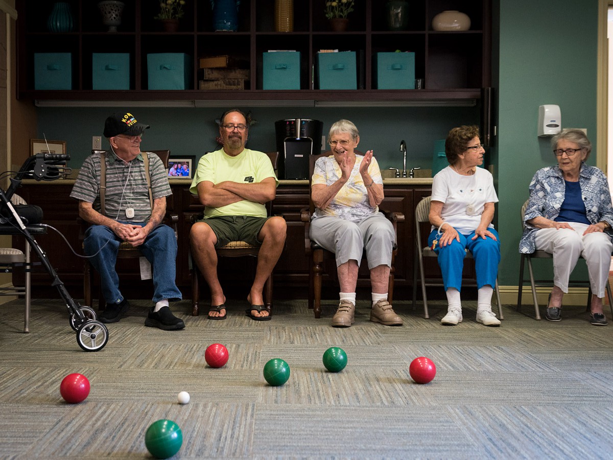 Seniors enjoying a game of bocce indoors at a community center.