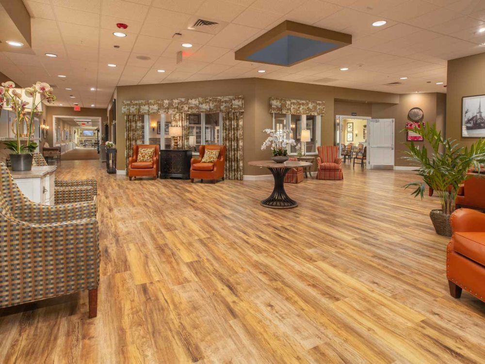 A spacious and modern lobby with wooden flooring and comfortable seating areas.
