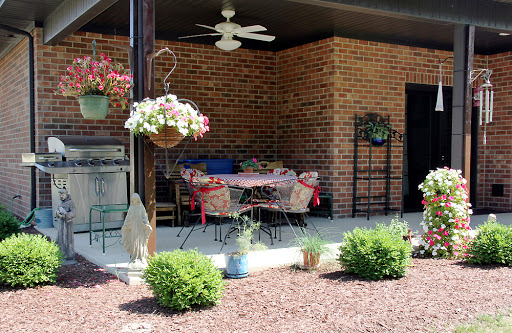 A cozy outdoor patio area decorated with flowers and equipped with comfortable furniture.