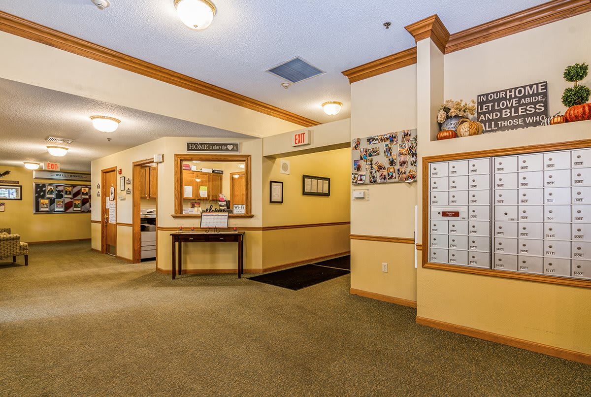 A well-lit lobby featuring mailboxes and a reception desk.