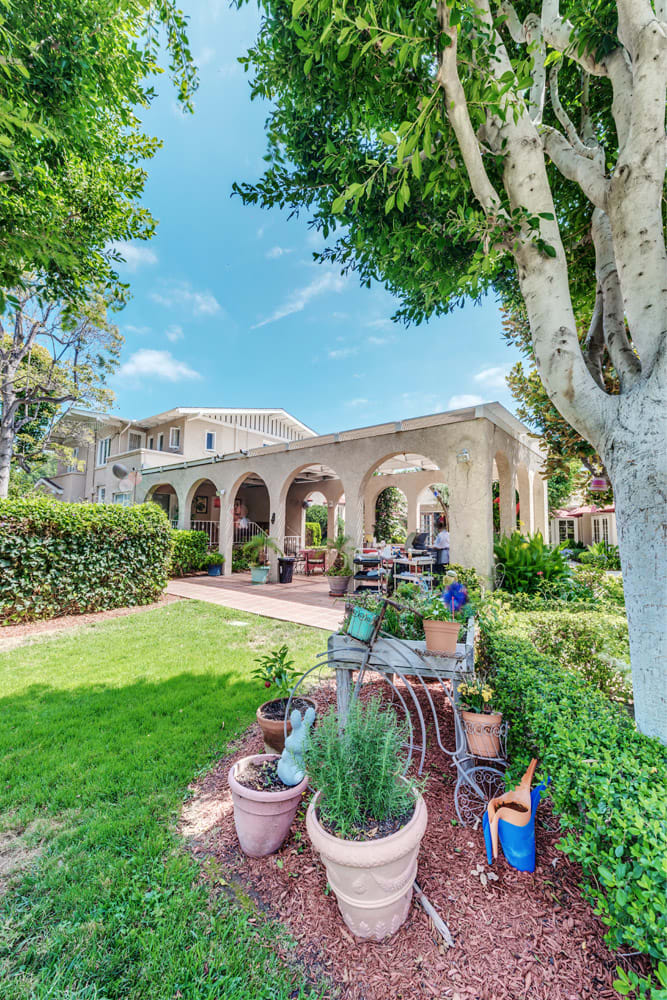 A beautiful garden with a spacious patio and arched architecture.