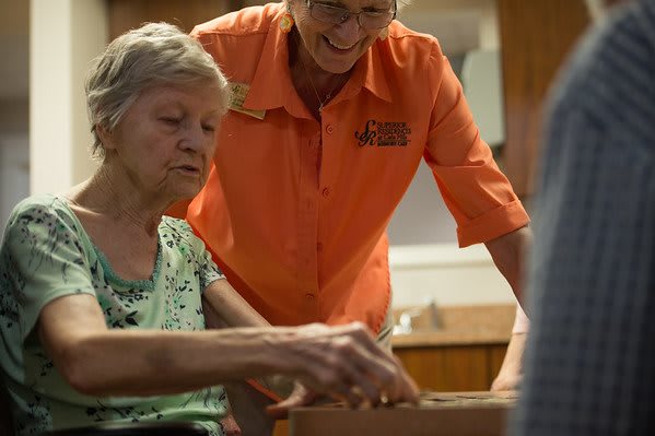 Two women engaged in conversation and activity, highlighting community care.