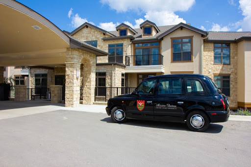 A black taxi parked in front of a stylish residential building on a sunny day.