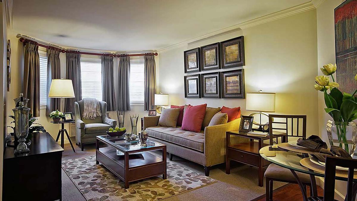 A cozy and modern living room with a sofa, armchair, coffee table, and decorative wall art.