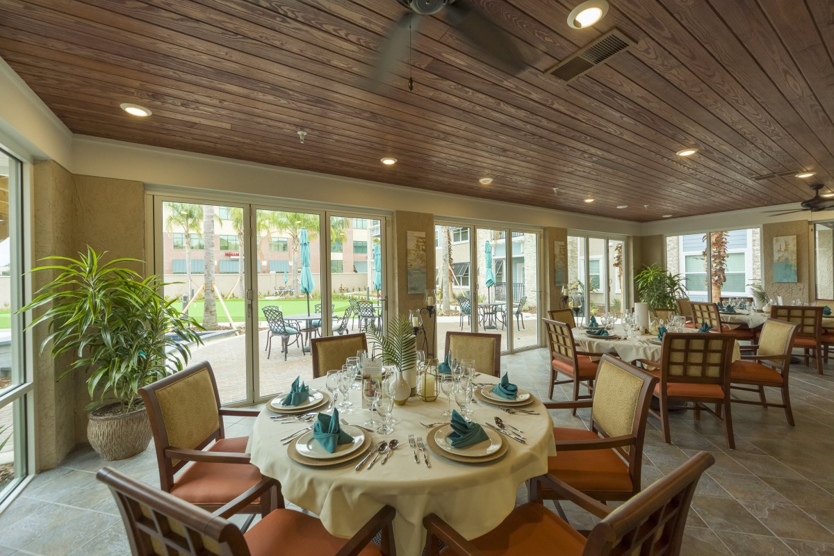 A beautifully set dining room with elegant decor and large windows letting in natural light.