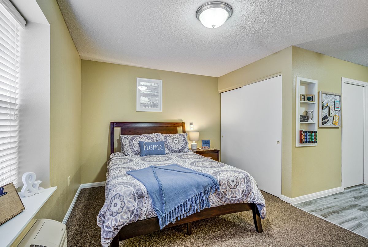 A cozy bedroom with a neatly made bed, warm lighting, and tasteful decor.
