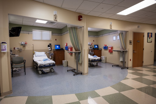 A view of patient rooms in a hospital, equipped with beds and monitoring equipment.