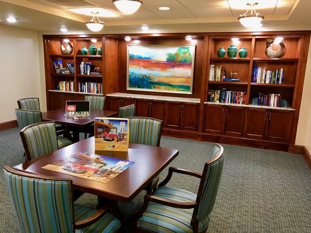 A cozy library area with bookshelves, comfortable seating, and colorful artwork.