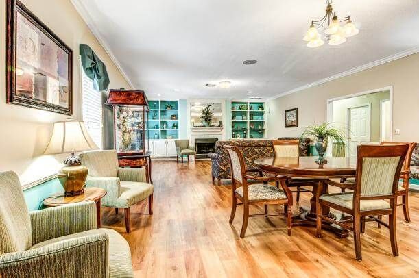 A spacious and cozy living room with a dining area, featuring hardwood floors and elegant furniture.