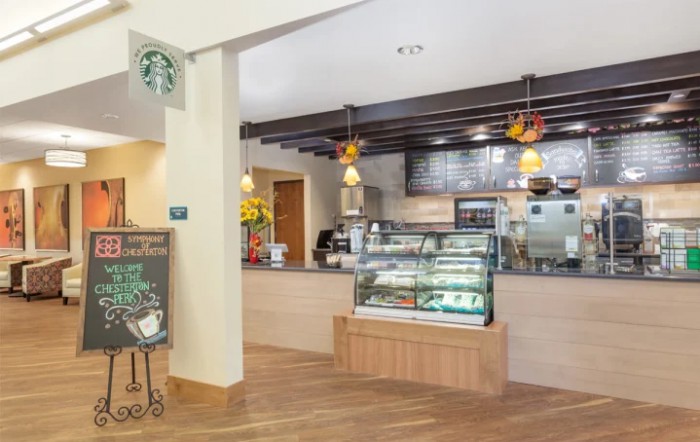 Interior of a Starbucks cafe with a display counter and menu.