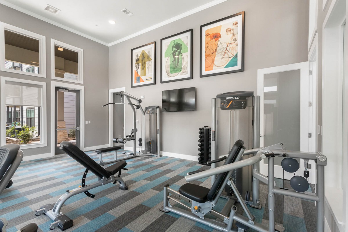 A modern gym with various fitness equipment and weights.