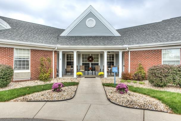 A well-maintained building entrance with neat landscaping and colorful flowers.