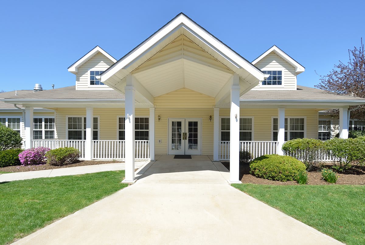 A large suburban house with a prominent porch and well-maintained lawn.