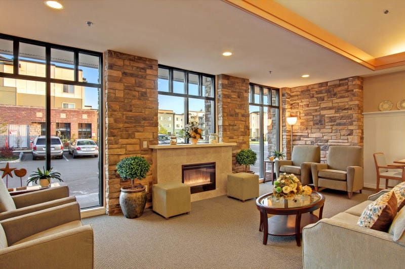 A modern lobby with comfortable seating, large windows, and a fireplace.