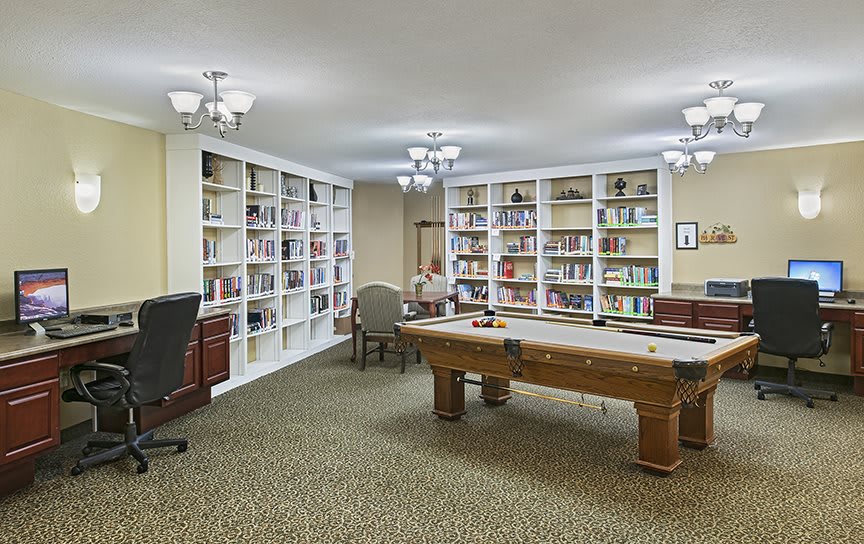 A cozy library with bookshelves and a large table in the center.