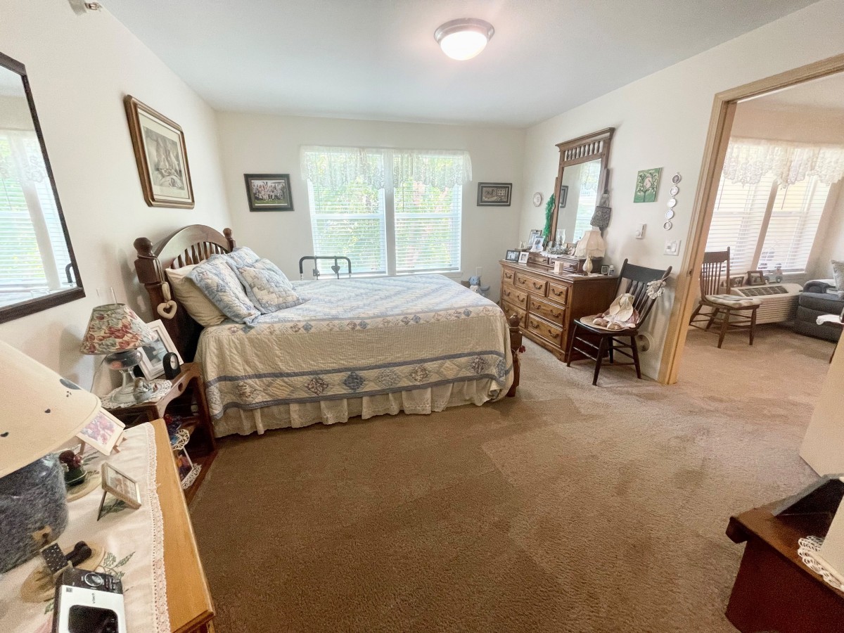 A cozy bedroom with a large bed and classic wooden furniture.