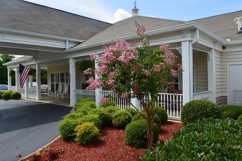A well-maintained building with a landscaped garden featuring colorful flowers and bushes.