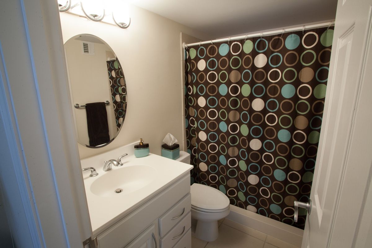 A modern bathroom with a colorful circular-patterned shower curtain.