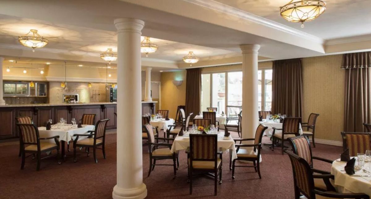 An elegant dining area with neatly arranged tables and chairs, featuring classic interior design and soft lighting.