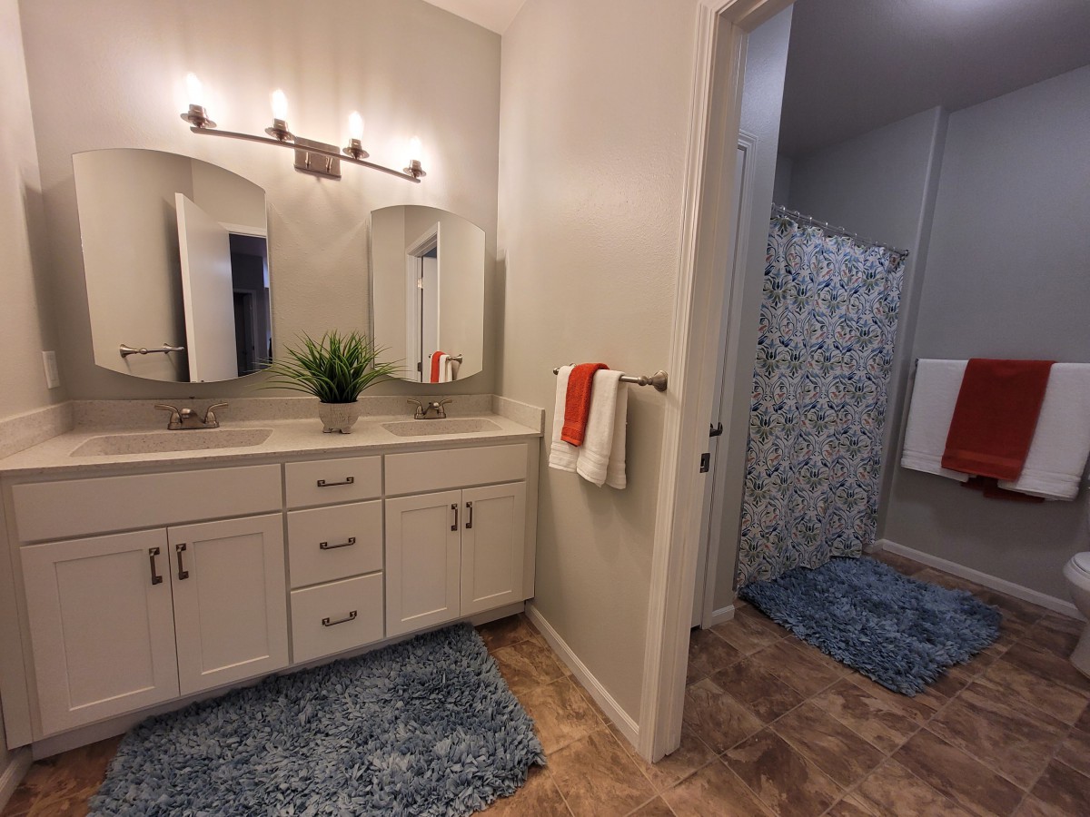 A well-lit bathroom with a vanity and shower area.