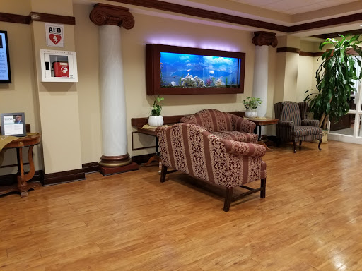 A cozy lobby area featuring a sofa, decorative aquarium, and plants.