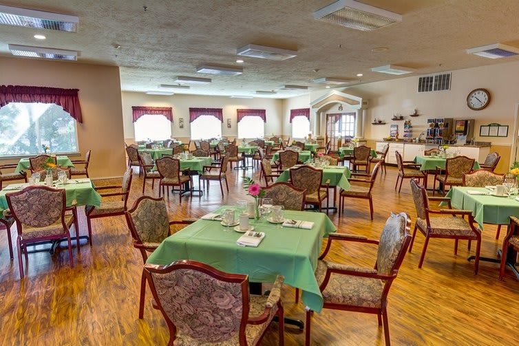 An empty dining room with neatly arranged tables and chairs.