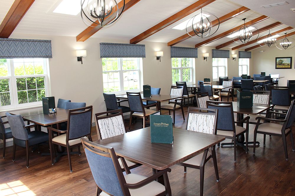 A modern dining room with tables and chairs arranged neatly under stylish lighting.