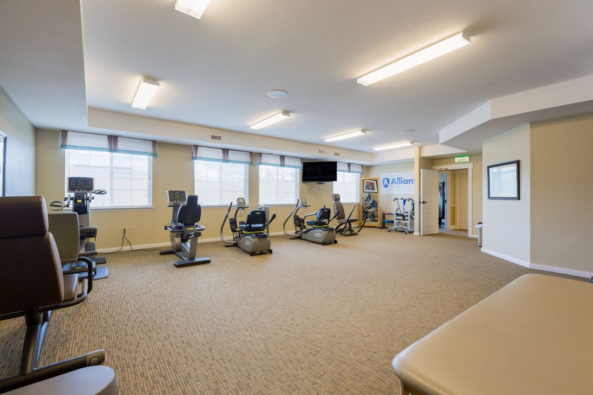 A well-lit fitness center with exercise equipment including stationary bikes and treadmills.