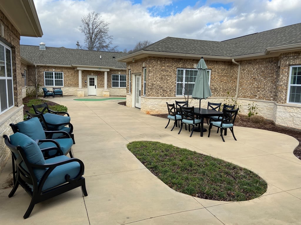 A courtyard with outdoor seating and a view of the building exterior under a cloudy sky.