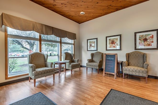 A cozy waiting room with comfortable chairs and large windows.
