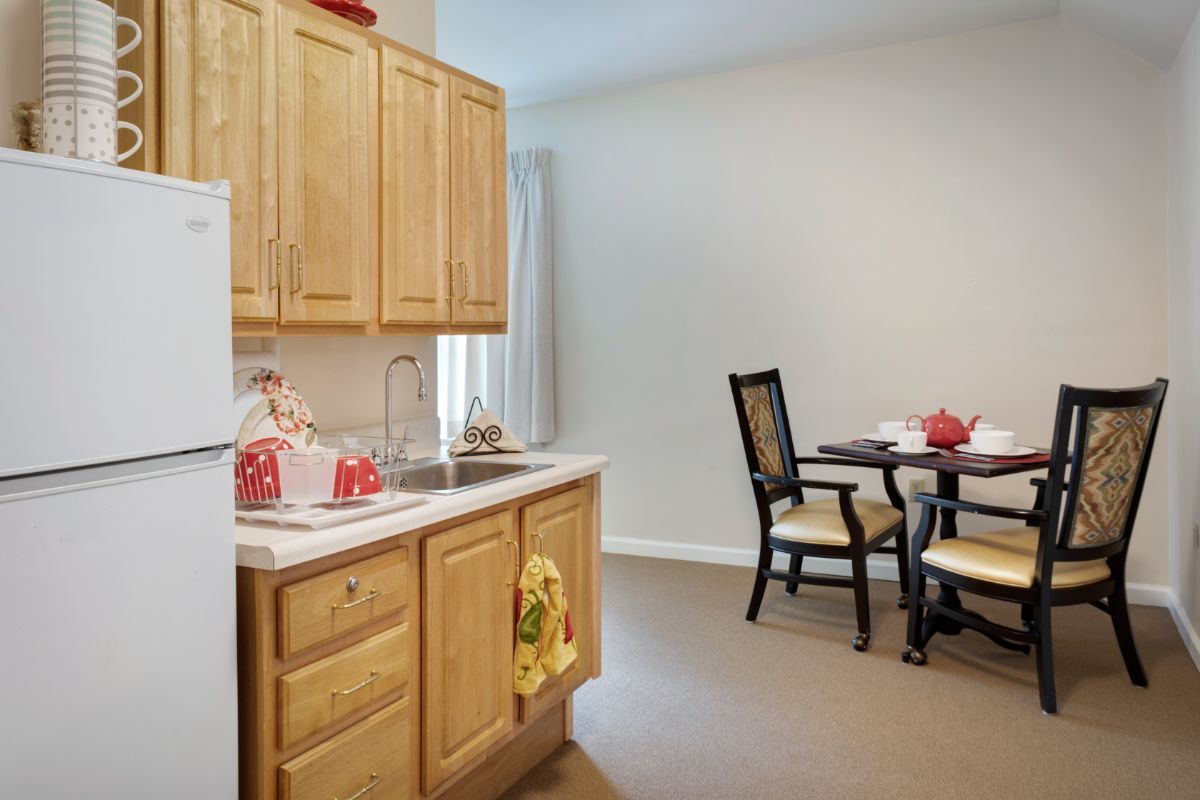 A cozy kitchen and dining area featuring wooden cabinets and a small dining table with chairs.