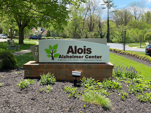 Entrance sign of the Alois Alzheimer's Center, surrounded by greenery.