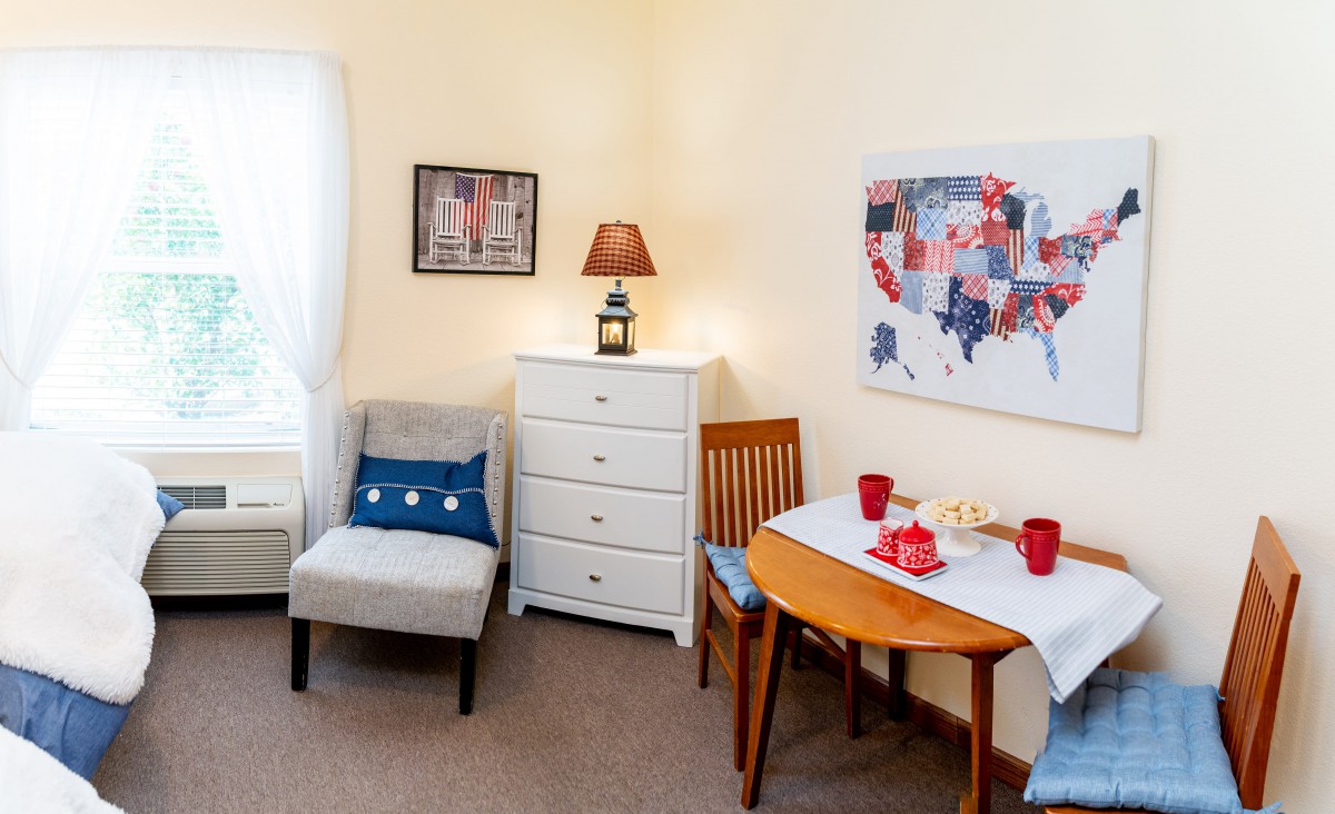 A cozy living room with a small table set, comfortable seating, and wall art featuring a map.