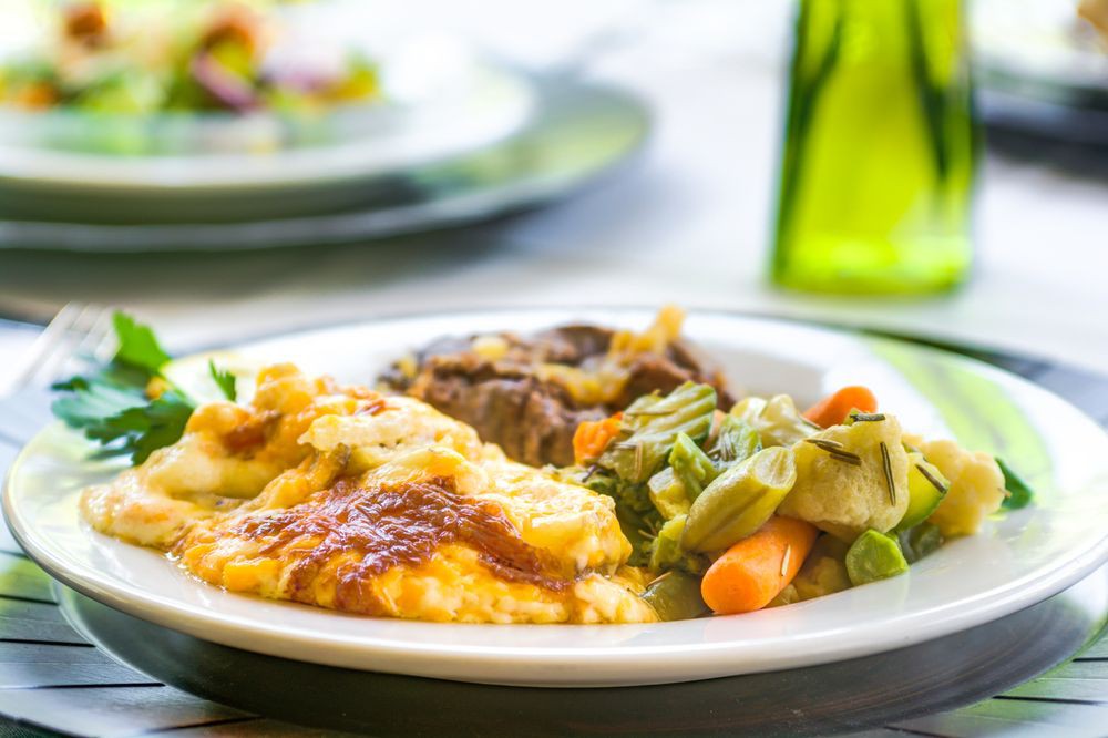 A plate of food with mashed potatoes, vegetables, and meat.