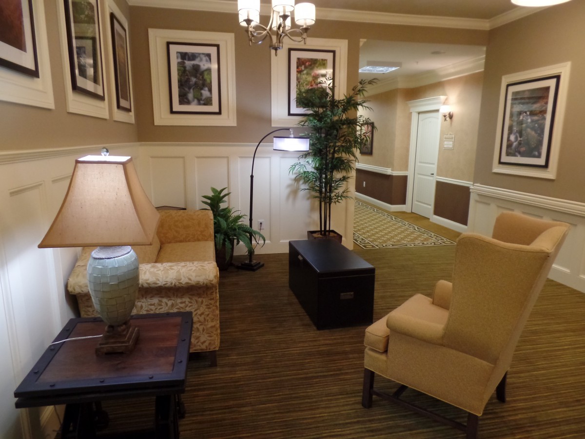 A cozy lobby with elegant furniture, warm lighting, and decorative plants.