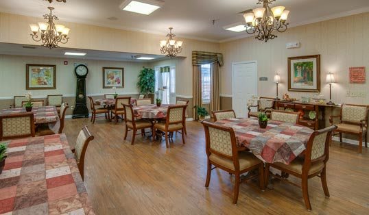 A well-appointed dining room with elegant chandeliers, tables, and chairs.
