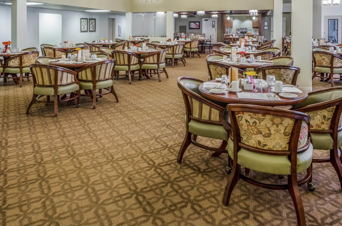 A spacious dining room with elegantly set tables and chairs.