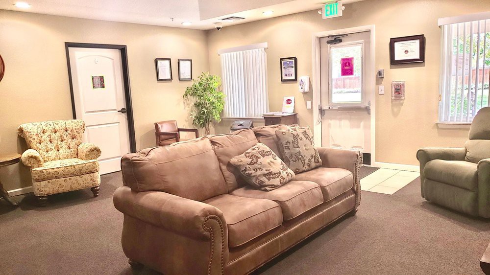 A cozy waiting room with a comfortable sofa and indoor plant.