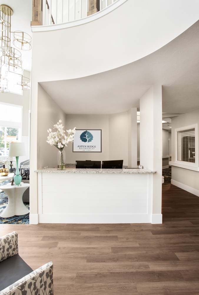 A modern and bright reception area with a decorative flower arrangement and office signage.